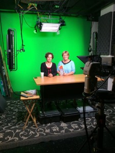 Andrea and I sitting in a NYC TV studio in front of a green screen.